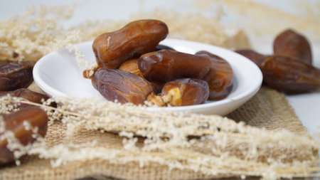 Dates have a distinctive taste with a chewy texture in the flesh. on the background is a brown bag...