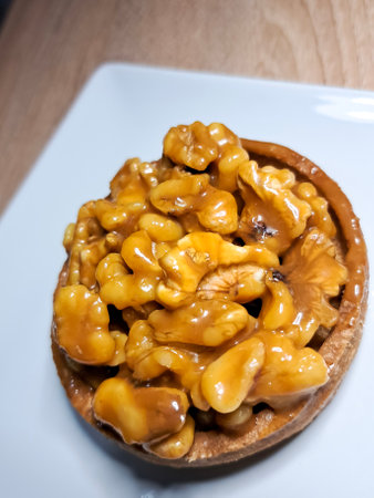 Walnuts on a white plate on a wooden table. Top view.の写真素材