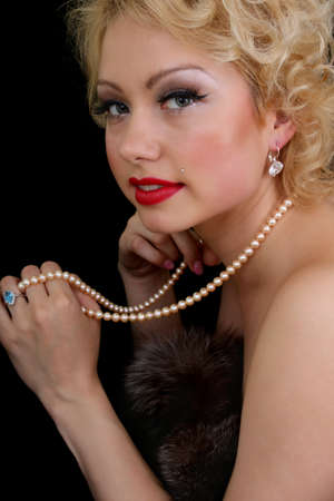 Blondie woman with pearl necklace in her handの写真素材