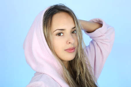 Portrait of young woman in bathrobe over blueの写真素材