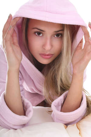 Portrait of young woman in bathrobe over whiteの写真素材