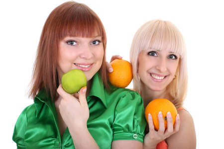 two young attractive women with green apple and oranges isolated over white backgroundの写真素材