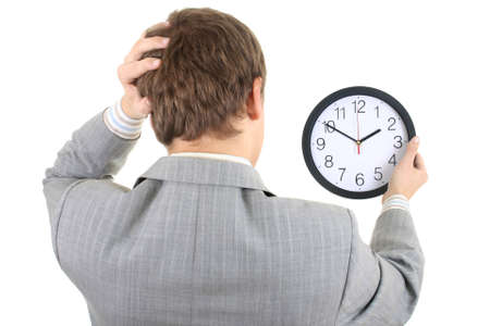 Shocked businessman holding a clock over white