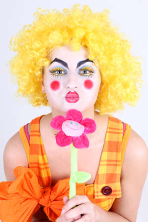 Funny clown in costume with colourful flowerの写真素材