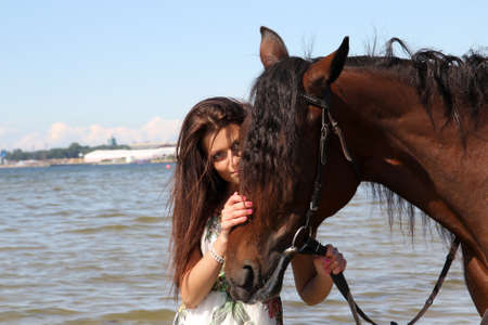 Girl with horse on the beachの写真素材