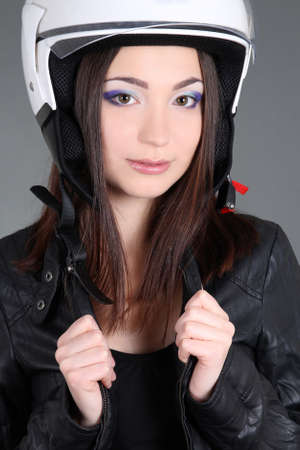 Biker woman in helmet on head over greyの写真素材