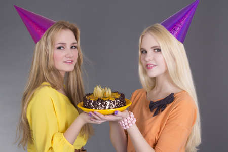 beautiful girls with birthday cake over greyの写真素材