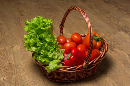 fresh vegetables in basket on wooden tableの写真素材