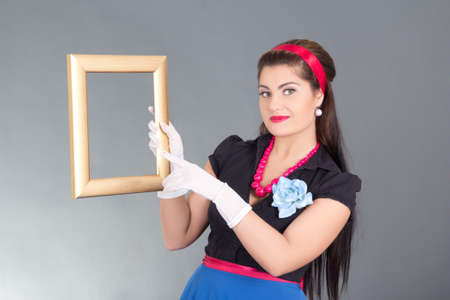pretty pinup girl with photo frame over greyの写真素材