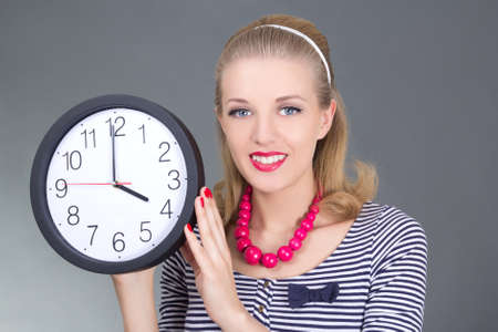 attractive pinup girl in striped dress with clock over grey