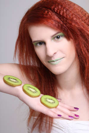 attractive redhaired girl with kiwi slicesの写真素材