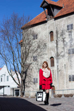 young attractive redhaired woman walking in medieval european townの写真素材