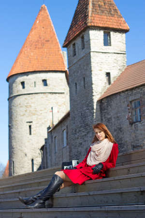 young attractive woman sitting on stairs in old townの写真素材
