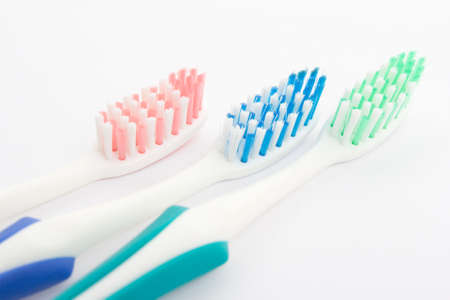 Red, green and blue toothbrush over whiteの写真素材