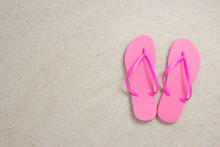 red flip flops on the white beach sand with copyspaceの写真素材