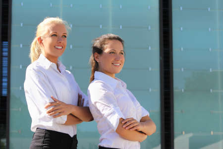 portrait of two young attractive business women posing outsideの写真素材