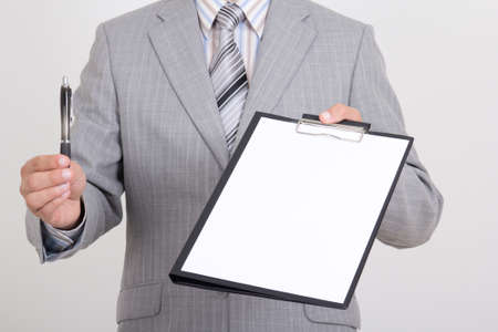 sheet of white paper and pen in business man handsの写真素材