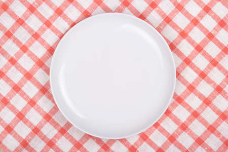 white empty plate over checkered backgroundの写真素材