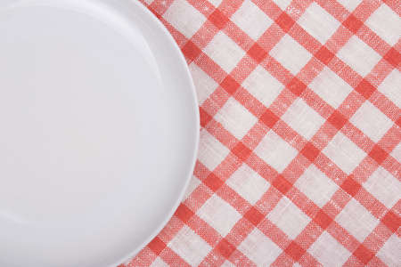 close up of white empty plate over checkered backgroundの写真素材