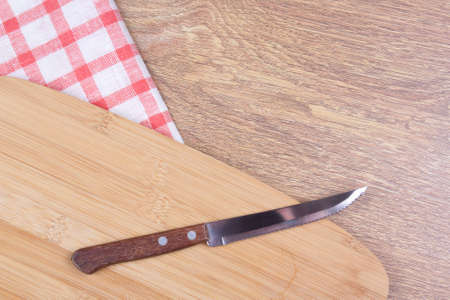 kitchen knife on the wooden table with checkered tableclothの写真素材