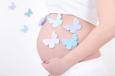 pregnant woman's belly with colorful butterflies の写真素材