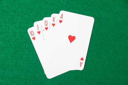 Poker cards with royal flush combination on green tableの写真素材