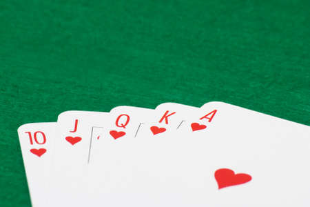 close up of poker cards with royal flush combination on green casino tableの写真素材