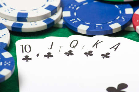 close up of a royal flush combination at poker with chips on the green table