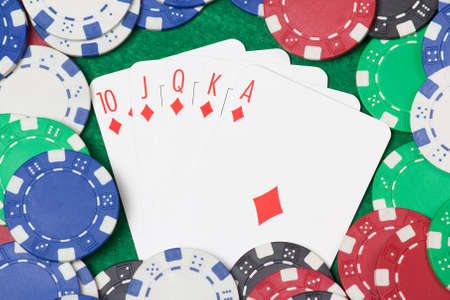 royal flush combination and poker chips on the green casino table