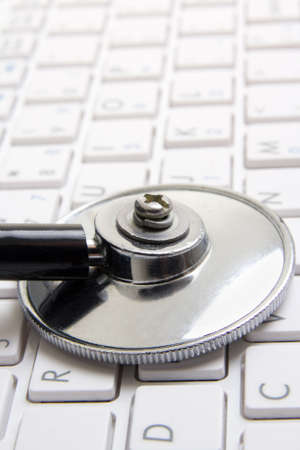 close up of stethoscope on white notebook keyboard