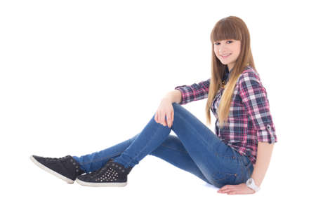happy teenage girl sitting isolated on white backgroundの写真素材