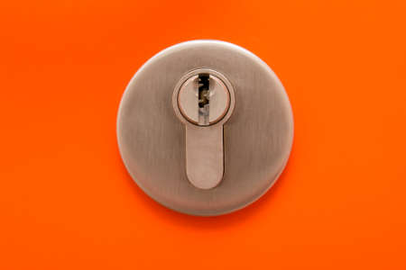close up of keyhole on orange metal doorの写真素材