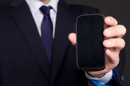 modern mobile phone with blank screen in business man handの写真素材