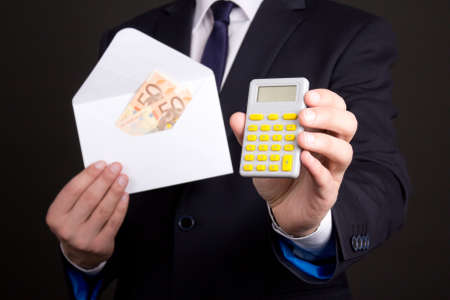 envelope with euro banknotes and calculator in business man hands