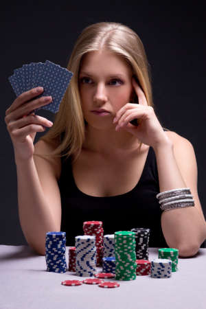 young beautiful serious woman playing poker in casinoの写真素材