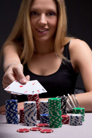 young blondie woman in casino with four aces in hand