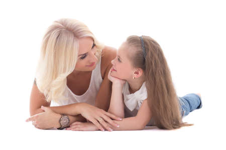 mother talking with her little daughter lying on the floor isolated on white backgroundの写真素材