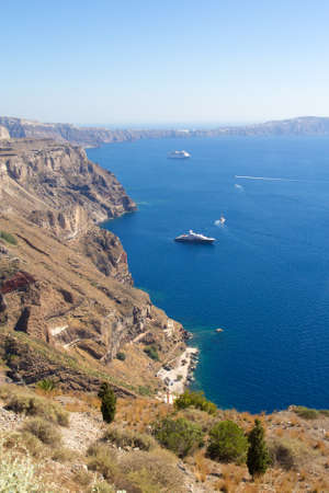 luxurious yachts and cruise ships in Santorini bay in Greeceの写真素材