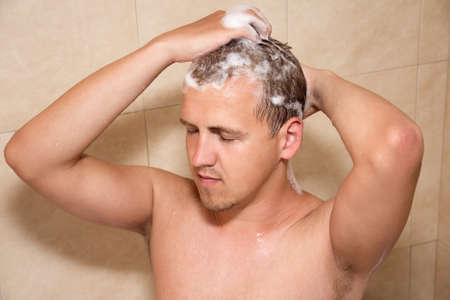 young attractive man showering in bathroomの写真素材