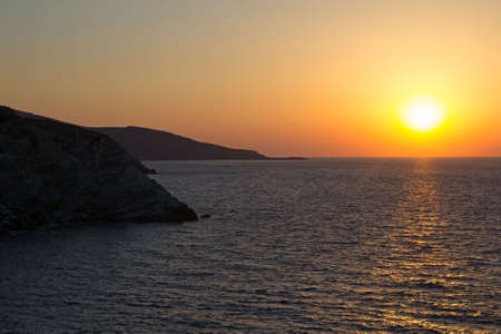 Beautiful sun setting/rising over sea horizon in Greeceの写真素材