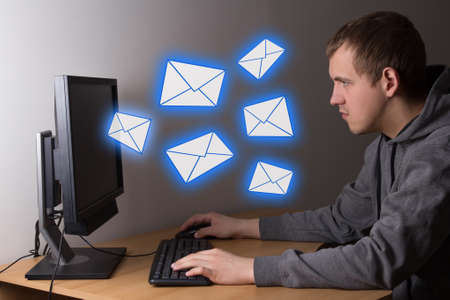 spam concept - young man using a computer at home
