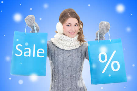 sale concept - young beautiful woman with shopping bags over snow christmas backgroundの写真素材