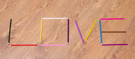 word love made by colorful pencils on wooden tableの写真素材
