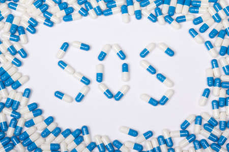 sos word text made of blue tablets, pills and capsules on white backgroundの写真素材