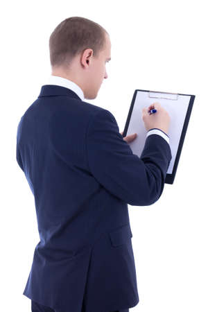 back view of young businessman in suit writing something in clipboard isolated on white backgroundの写真素材
