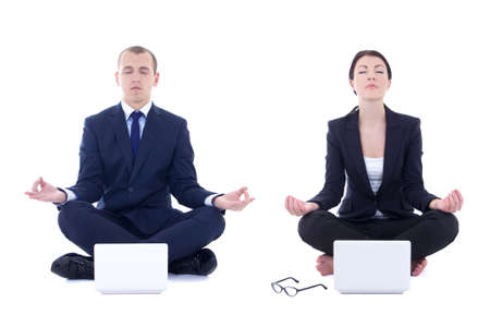 young business man and beautiful business woman sitting in yoga pose with laptops isolated on white backgroundの写真素材