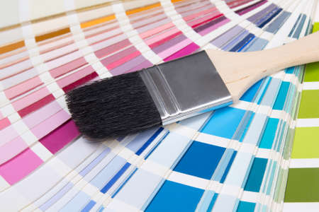 close up of wooden painter's brush over colorful palette