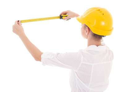 back view of business woman architect in yellow builder helmet with measure tape isolated on white backgroundの写真素材