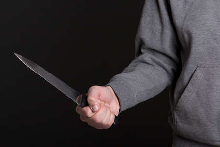 close up of knife in male hand over grey backgroundの写真素材