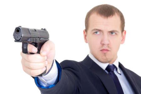 serious man in business suit shooting with handgun isolated on white backgroundの写真素材